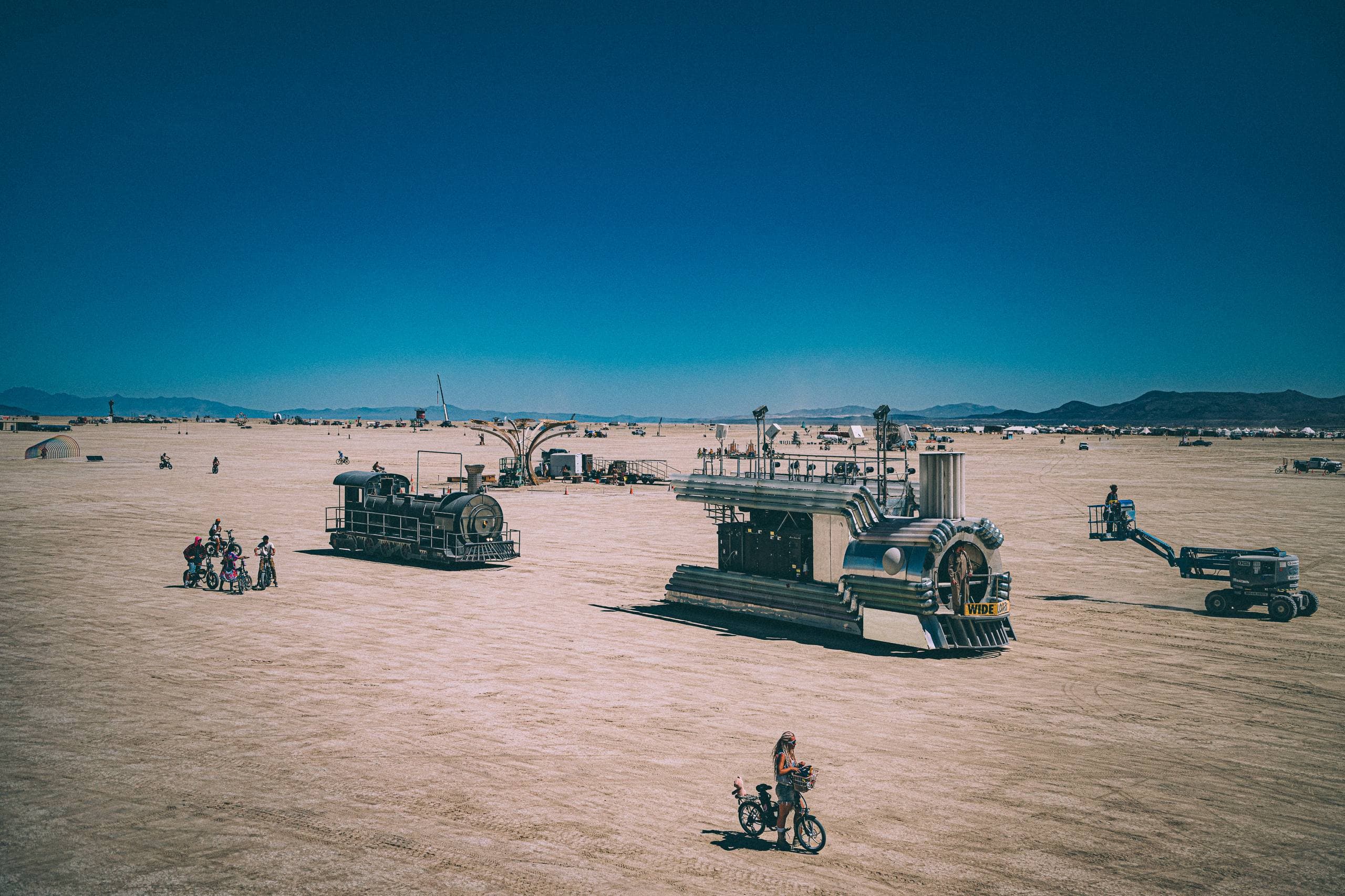The two BiPolar Express train art cars crossing the open Playa on their way to DMV inspection