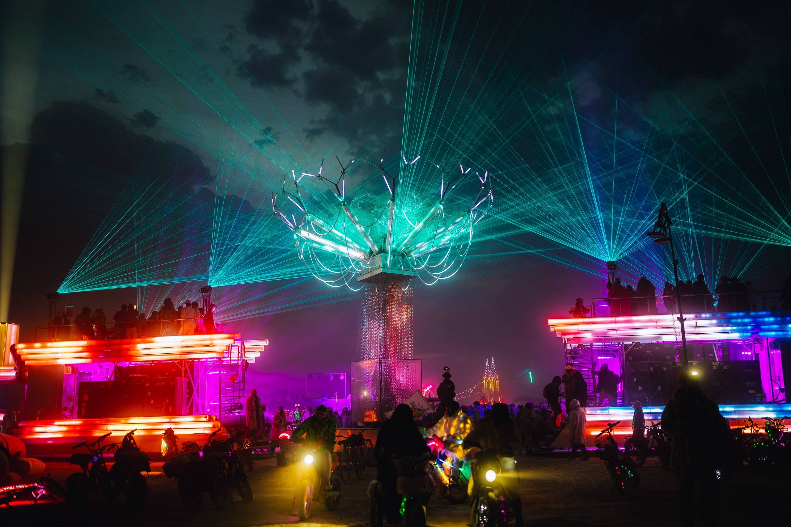 Singularity Tree illuminated between the two BiPolar Express trains beneath a field of lasers at Burning Man
